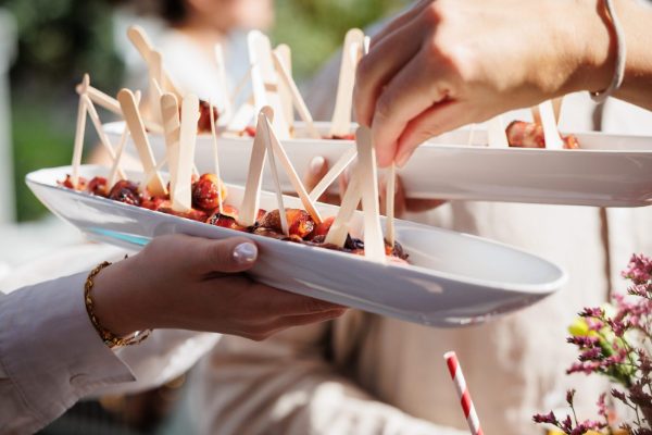 Fingerfood wird auf einem Sommerfest an die Gäste serviert