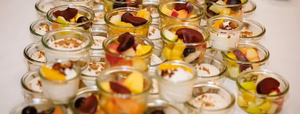 Obstsalat und Quarkcreme in Weckgläschen auf dem Dessertbuffet